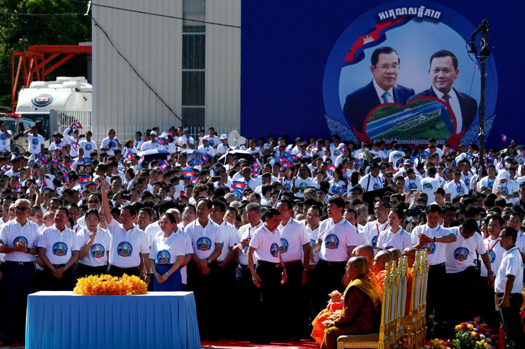 Cambodia's Prime Minister Hun Manet waves to a crowd with images of his himself and his father, former prime minister Hun Sen, on wide display during the groundbreaking ceremony of the Funan Techo Canal in Kandal province (Tang Chhin Sothy/AFP via Getty Images)